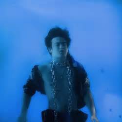 Joji cast in chains sinking down in the ocean. Album cover for his first major release In Tongues. Used under fair use.