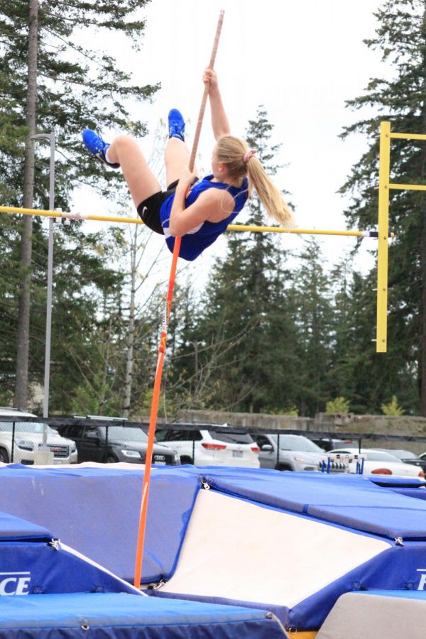 This season, a pole vaulter springs into action at a Track and Field meet, representing Tahoma High School against another school, seen here jumping over the bar. 