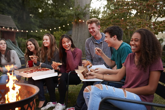 A group of teens hang out together, eating pizza. Picture Credit: fona.com
