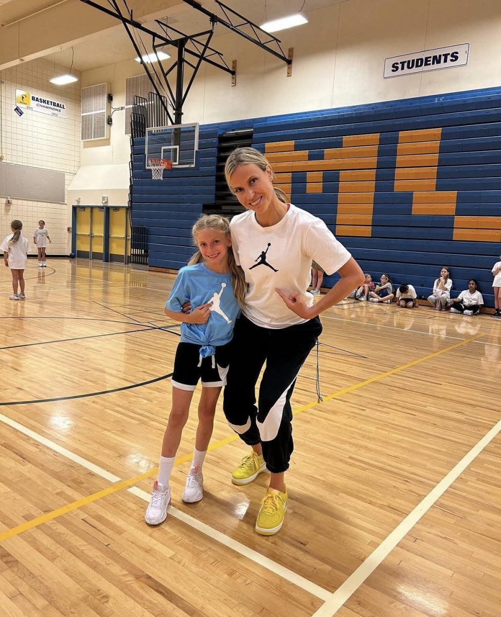 Julie Anderson with young player at team camp.
